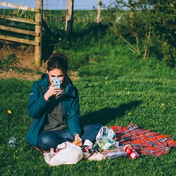 woman sitting on the grass having a picnic (image: Luke Porter on Unsplash)